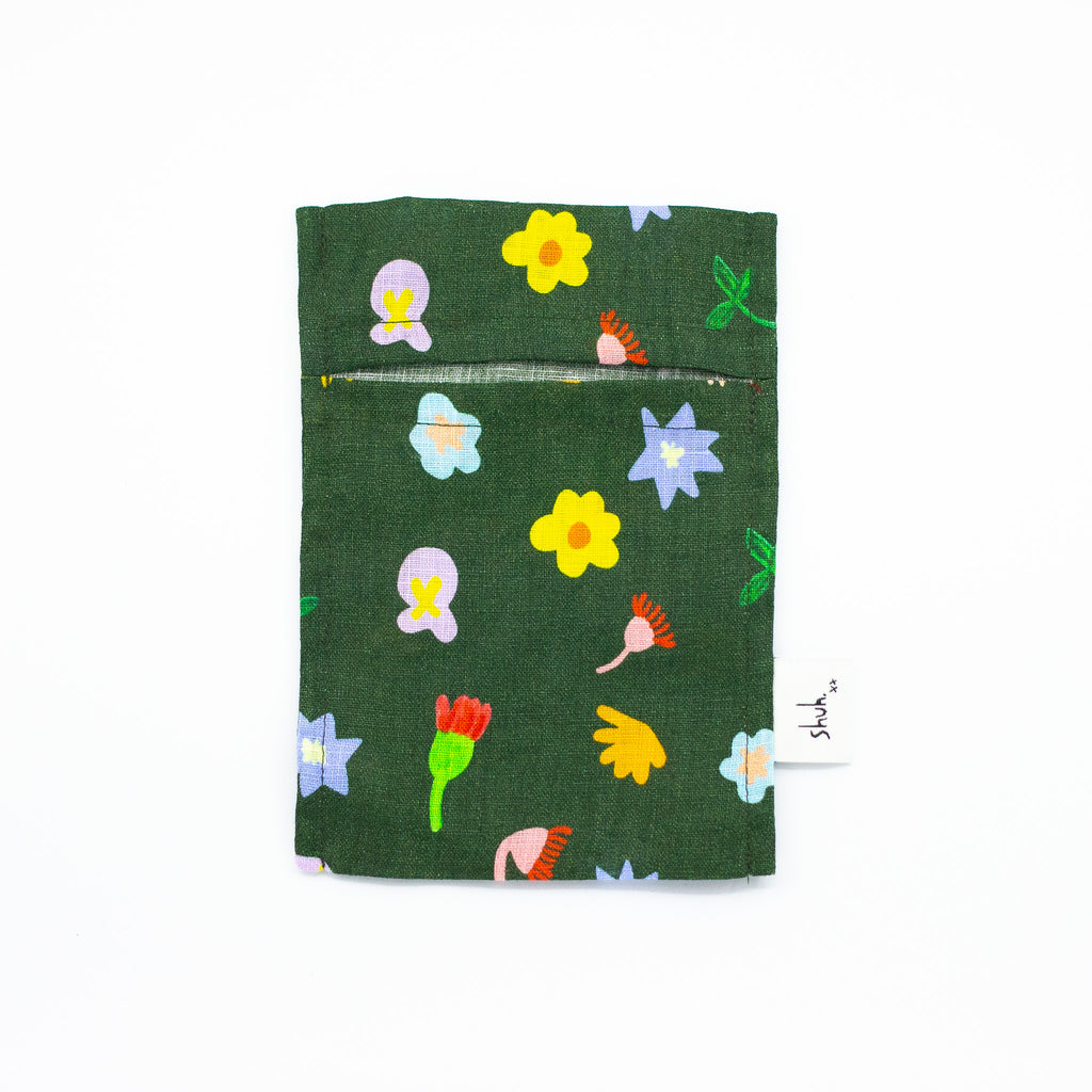 Front view of the Meadow pocket tissue holder. Illustrated wildflowers on a meadow green background