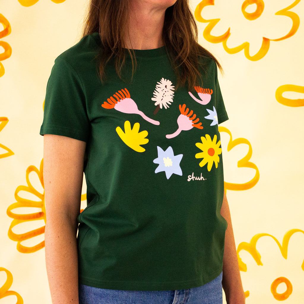 Front view of the meadow tee. Green coloured tee with printed native flowers.