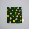 Small green pouch with colourful floral patterns on a grey background