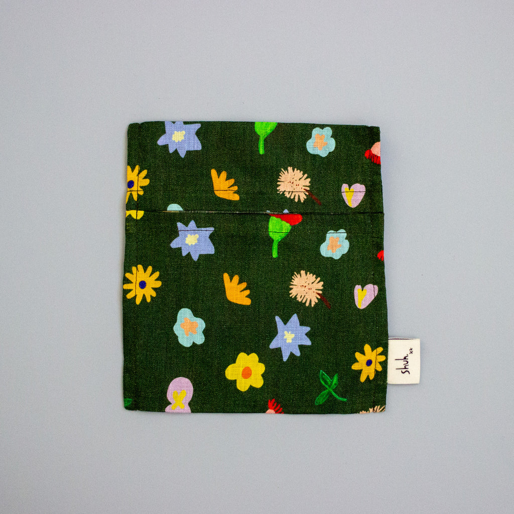 Small green pouch with colourful floral patterns on a grey background