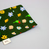 Fabric with colourful floral pattern on a green background, featuring a 'shuh' label.