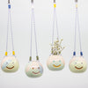 Four ceramic hanging planters with smiling faces on a white background