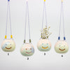 Four ceramic hanging planters with smiley face designs on a white background