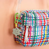 Colorful patterned bag with a ceramic charm on a beige background