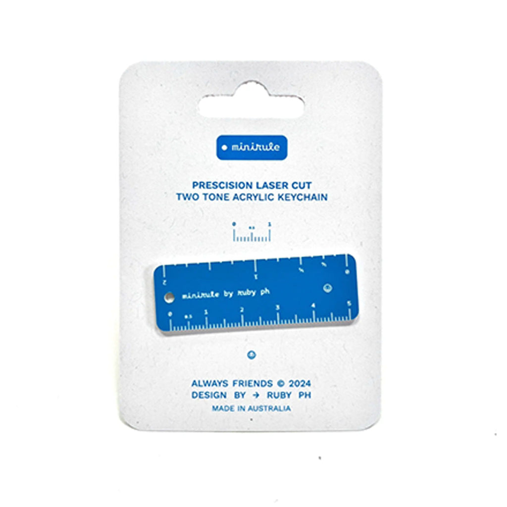 A blue and white acrylic keychain ruler on its original white cardboard packaging, branded 'minirule' by Ruby Ph.