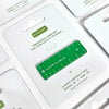 A green and white acrylic keychain ruler displayed on its white retail packaging card, with other cards partially visible in the background.
