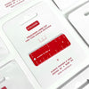 A red acrylic precision laser-cut ruler keychain displayed on its white backing card, which features product text and branding.