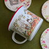 Illustrated mug with cartoon characters on a green surface