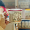 Person holding a mug with a rabbit illustration in a cozy indoor setting