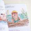 An open children's book showing a watercolour illustration of a beaver wearing a yellow hard hat and blue overalls while working on a dam, with bilingual text on the pages.
