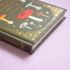 Book with mushroom illustrations on a green cover against a purple background