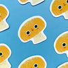 A cute mushroom character magnet with a blue background featuring more of these magnets.