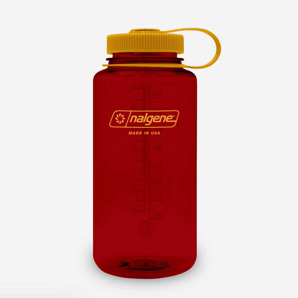 A translucent red Nalgene water bottle with a mustard screw cap and matching yellow carrying loop, shown on a clean white background.
