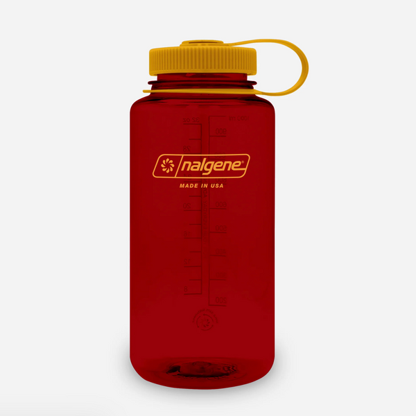 A translucent red Nalgene water bottle with a mustard screw cap and matching yellow carrying loop, shown on a clean white background.