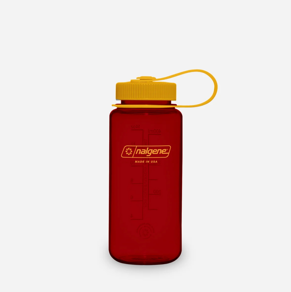 A translucent red Nalgene water bottle with a mustard screw cap and matching yellow carrying loop, shown on a clean light grey background.