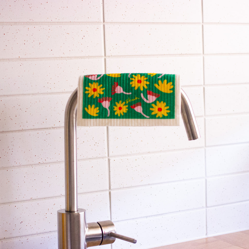The native flora shuh and spruce dishcloth hanging from a tap. 