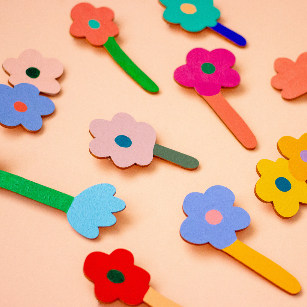 Colourful wooden flowers arranged on a peach background