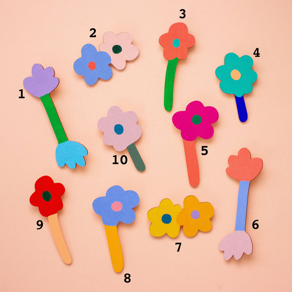 Colourful wooden flowers with numbers arranged on a peach background