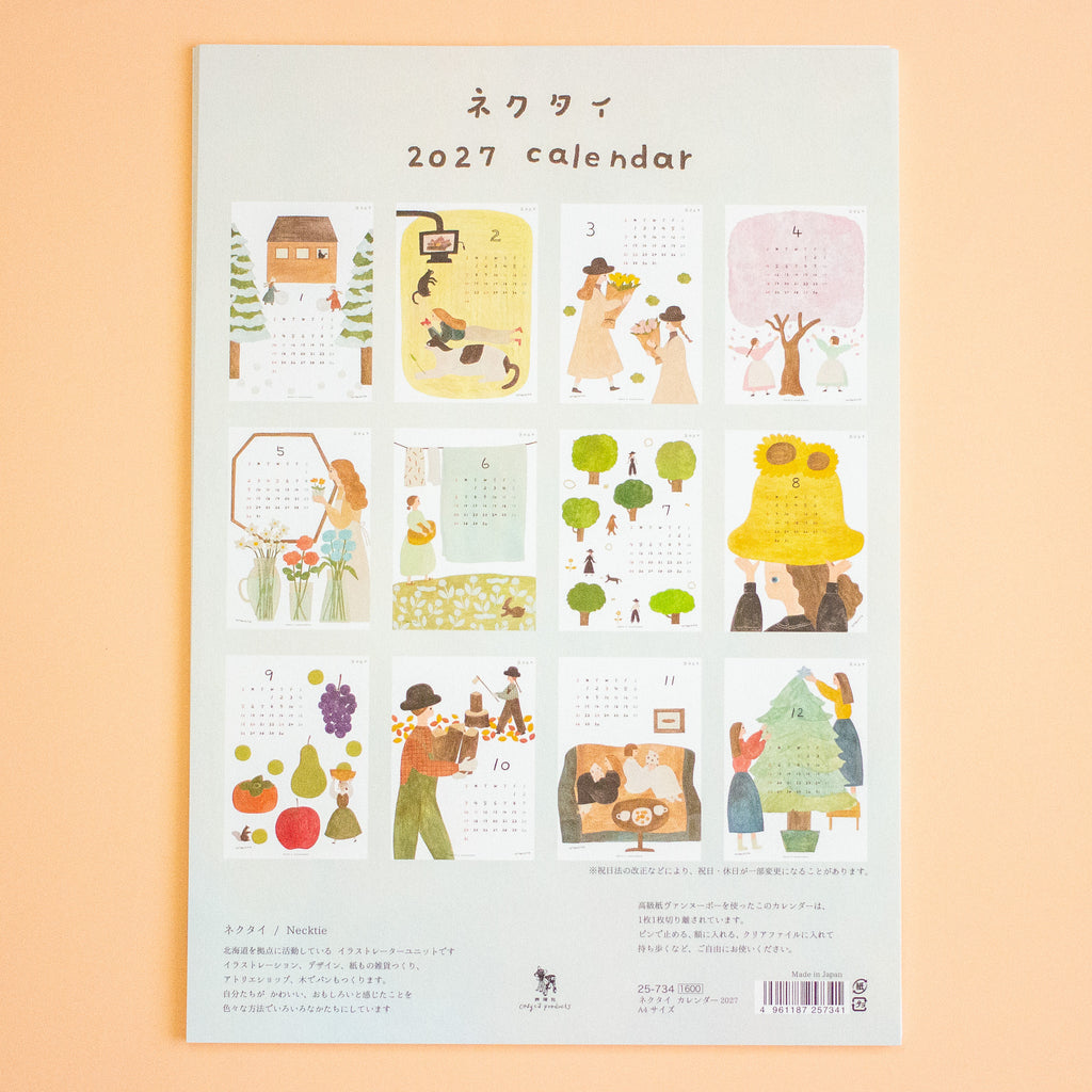 A 2027 calendar with illustrated monthly pages, photographed flat against a soft peach background. The cover shows the title '2027 calendar' in Japanese and English, plus small cover artwork and text blocks.