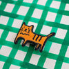 Embroidered patch of a cat on a green and white checkered background