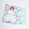 A Neko Hana letter writing set featuring a light blue envelope with a floral pattern, a matching writing sheet of a cat in a dress, all arranged on a white background.