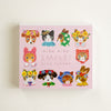 A square pink memo pad titled 'niko niko SMILE!' by Aiko Fukawa, featuring cute illustrated animals in colourful floral outfits on a light background.
