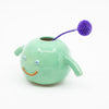 Side view of the Nishi Vase holding a flower. Green vase with purple flower. 