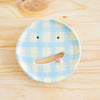 Top view of the Nola soap dish. Blue and yellow checkered design, open mouth with pink tongue. 