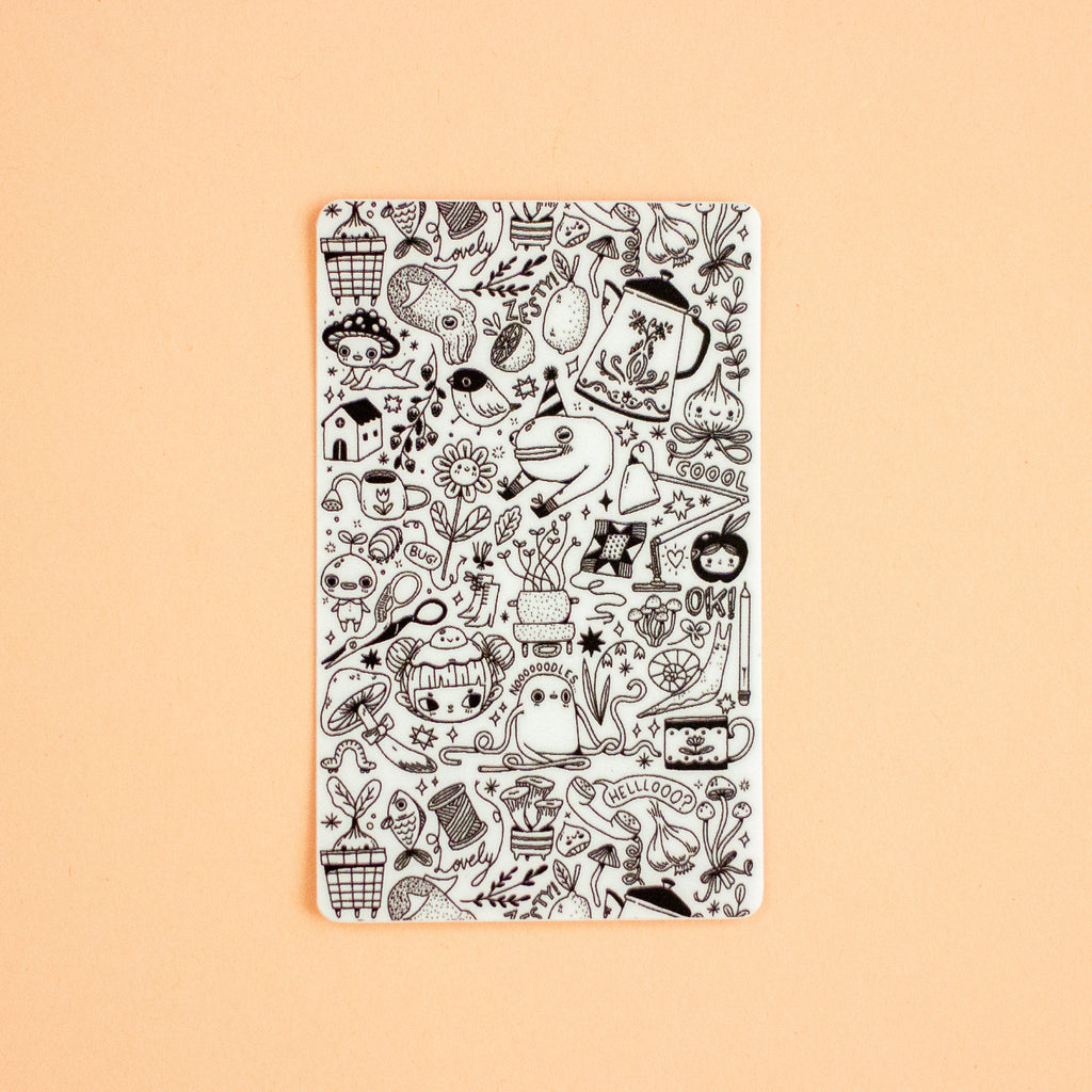 A rectangular sticker with a white cover decorated with black hand-drawn doodles, centered on a solid peach-coloured background.