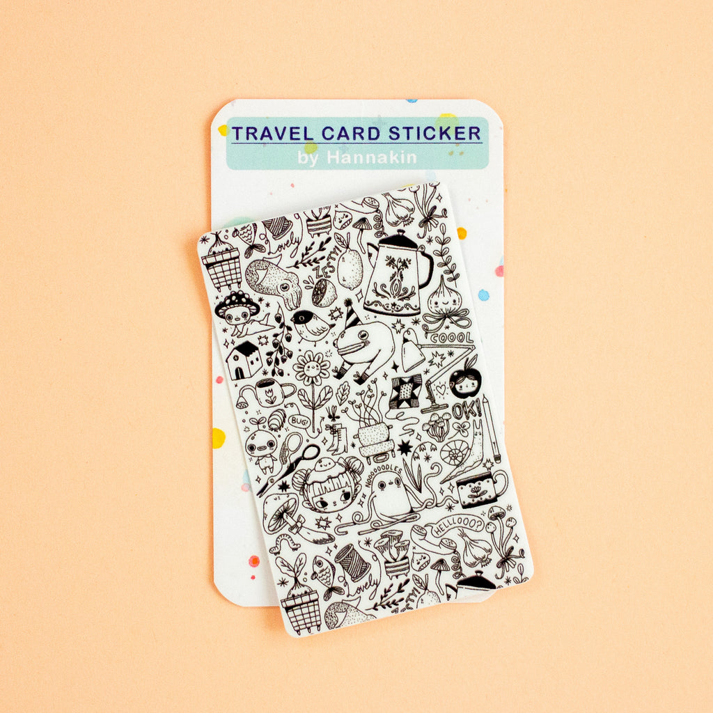 A travel card sticker sheet featuring black hand-drawn doodle illustrations on a white backing card, displayed on a solid peach background. The brand name 'Hannakin' is visible on the header card.
