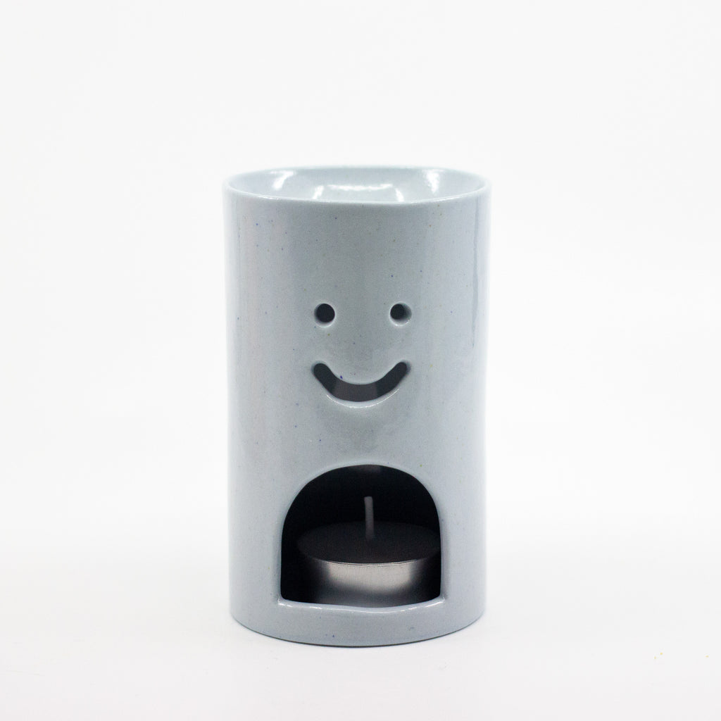 Pastel Blue ceramic oil burner with smiley face design on a white background