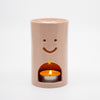 Ceramic oil burner with a smiley face design on a white background