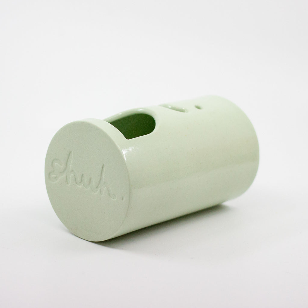Light green oil burner a shuh. brand logo on the bottom on a white background