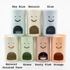 Set of cylindrical oil burners with smiley faces in various colors and finishes.