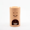 Pastel Orange Ceramic oil burner with smiley face design on a white background