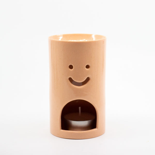 Pastel Orange Ceramic oil burner with smiley face design on a white background