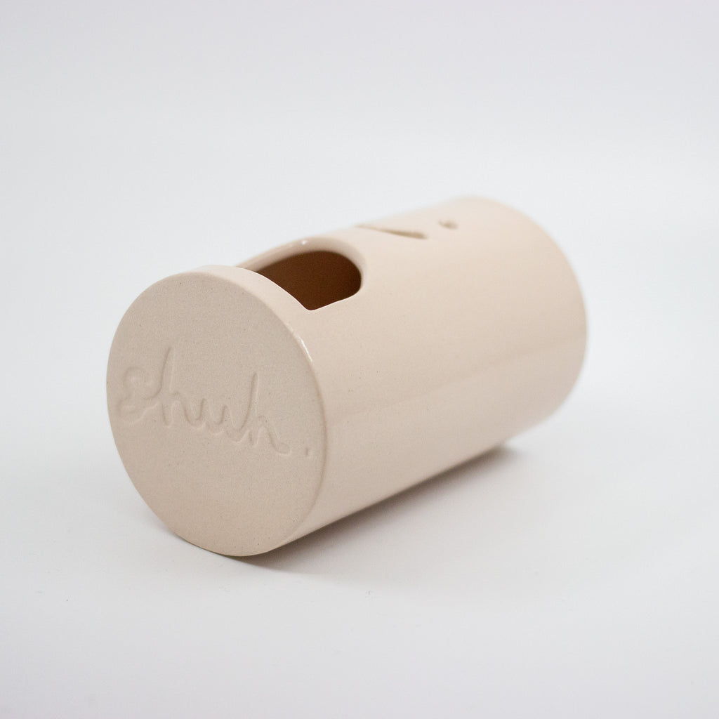 Pink cylindrical oil burner with a lid on a white background