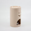 Pink ceramic oil burner with smiley face design on a white background