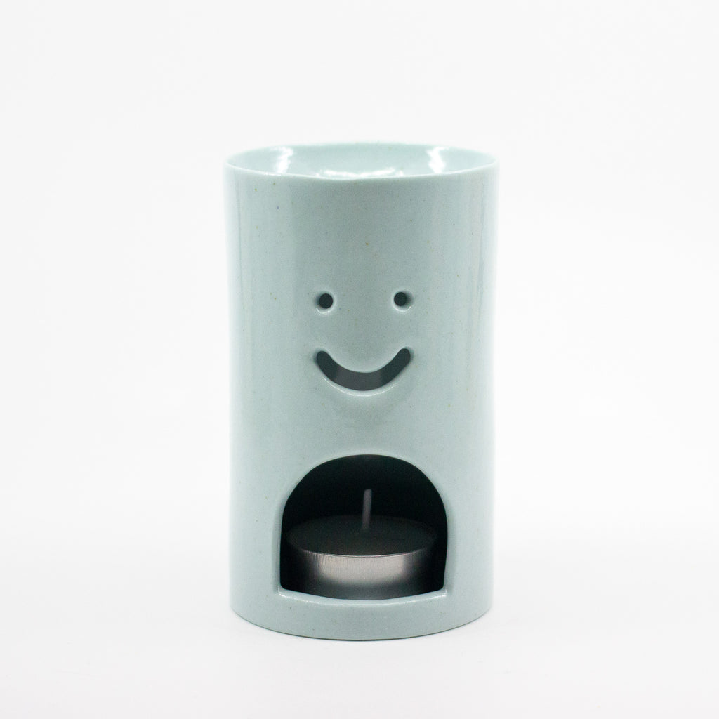 Light Blue Ceramic oil burner with smiley face design on a white background