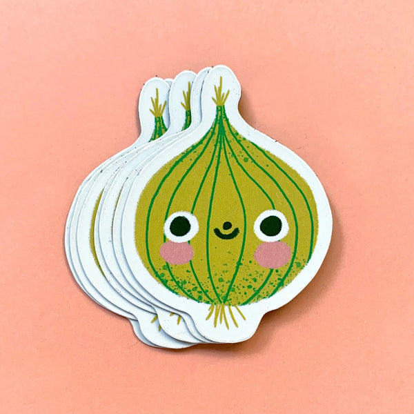 Stack of cute cartoon onion magnets on a peach background