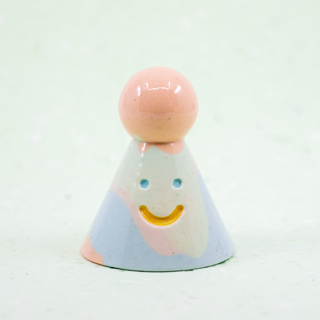 Pastel-colored figure with a smiling face on a white background