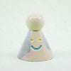 Small ceramic figure with a smiling face on a white background