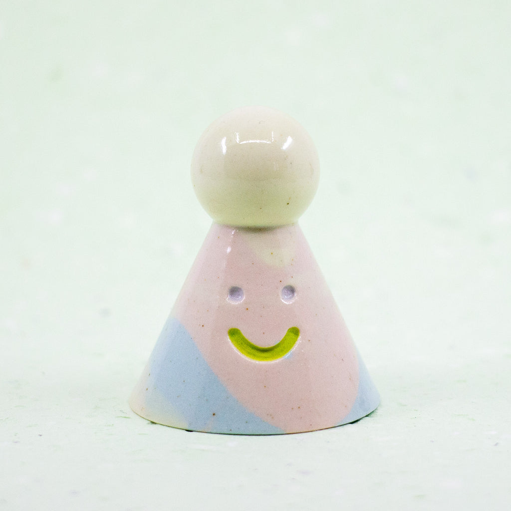 Colorful ceramic figure with a smiley face on a white background