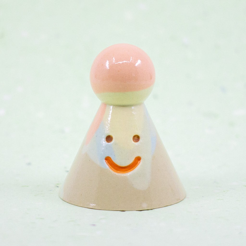 Ceramic figurine with a smiling face on a white background