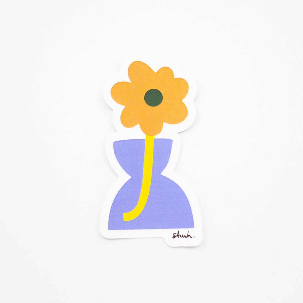 A yellow flower in a Pear shaped vase. 