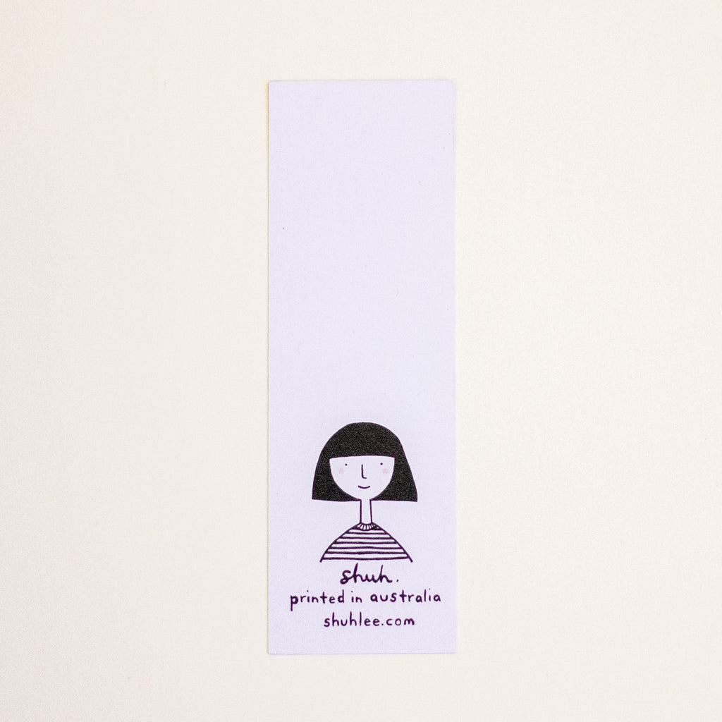 A tall, narrow white rectangular bookmark with a simple black line drawing of a person with short dark hair and the text 'shuh. printed in australia shuhlee.com'.