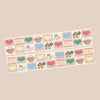Two decorative strips with a repeating cross-stitch style pattern of hearts, baskets, flowers, houses, and the letters ABC, shown on a plain beige background.