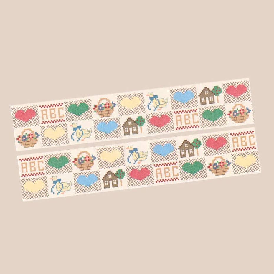 Two decorative strips with a repeating cross-stitch style pattern of hearts, baskets, flowers, houses, and the letters ABC, shown on a plain beige background.