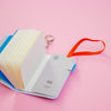 Open notebook with a keychain on a pink background