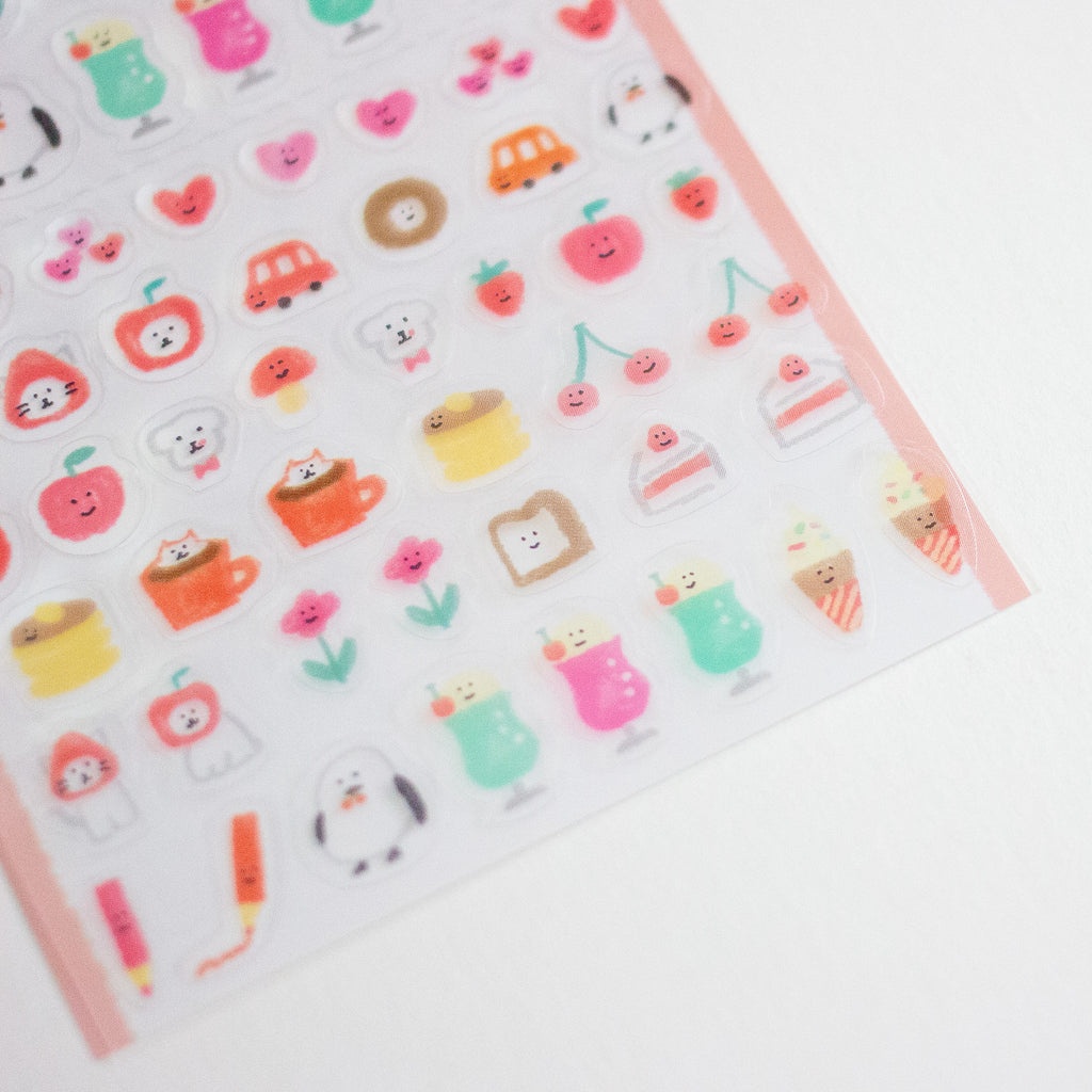 A close-up of a clear sticker sheet featuring cute, colourful cartoon stickers of desserts, drinks, and small characters on a white background.